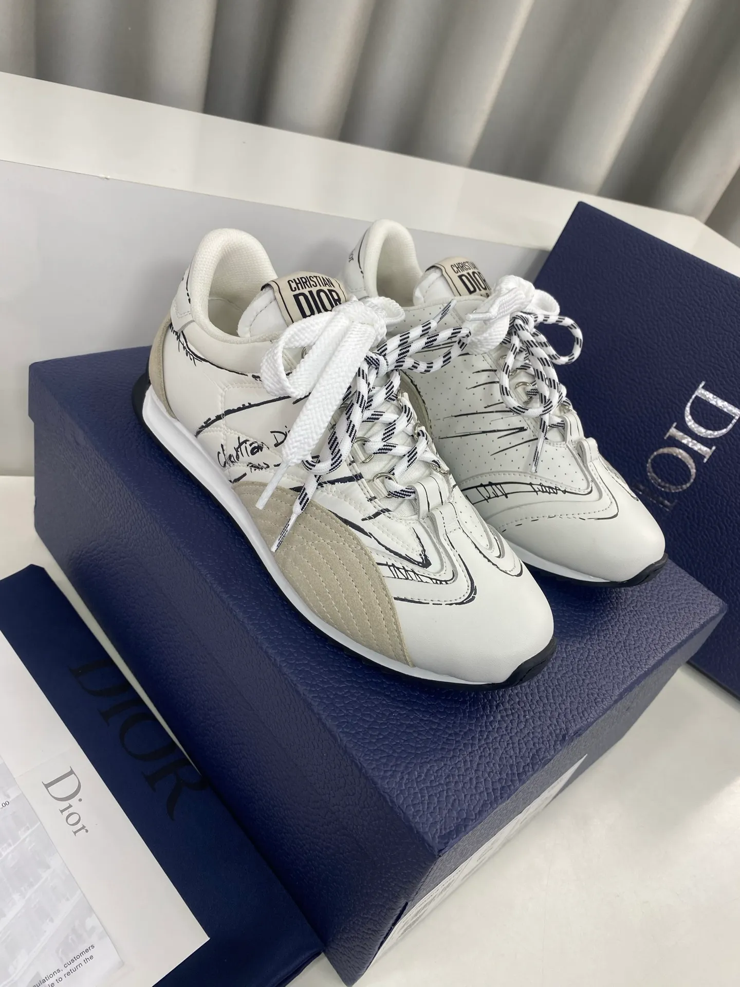 👟👟Ex-factory price 560👟👟 Men's size +10 Dior Dior D-Sketch series graffiti moral shoes casual sports shoes ☑️ D-Sketch sports shoes made a wonderful appearance at the Dior 2025 spring and summer ready-to-wear series show, highlighting the classic retro aesthetics. Crafted from white nylon and calf leather, it's finished with a printed logo inspired by the shoe's production stages, with beige suede calf leather panels and double laces. A handwritten Christian Dior Paris signature adorns the sides, while a Christian Dior Paris signature panel and plaque adorn the heel and tongue. Paired with two-color thin rubber soles, they are more refined and can add high-end temperament to various casual looks. Exquisite packaging at the delivery counter🛍📦 ▪️Fabric: Original customized cowhide/graffiti ▪️Inner foot pads: Breathable mesh ▪️Sole: Original molded non-slip rubber outsole ▪️Sole thickness: 2CM ▪️Size: 35-45 (45 for women and 45 for men, customization is not returnable)